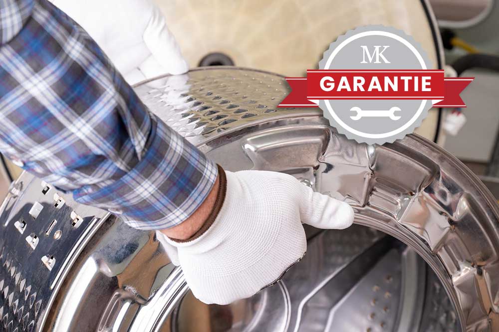 Hände in weißen Schutzhandschuhen halten eine glänzende Edelstahltrommel eines Wäschetrockners, im Vordergrund ist ein Garantiesiegel des MK Reparaturservice eingeblendet.
